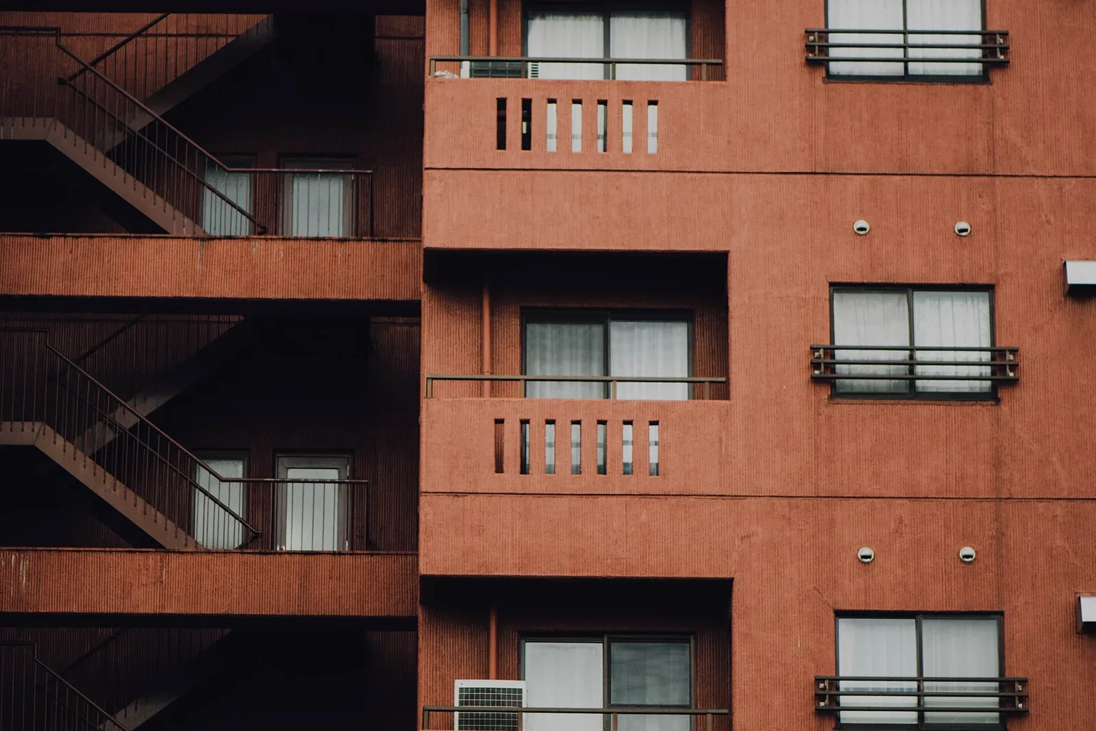 The facade of a mid-rise condo building with rows of windows