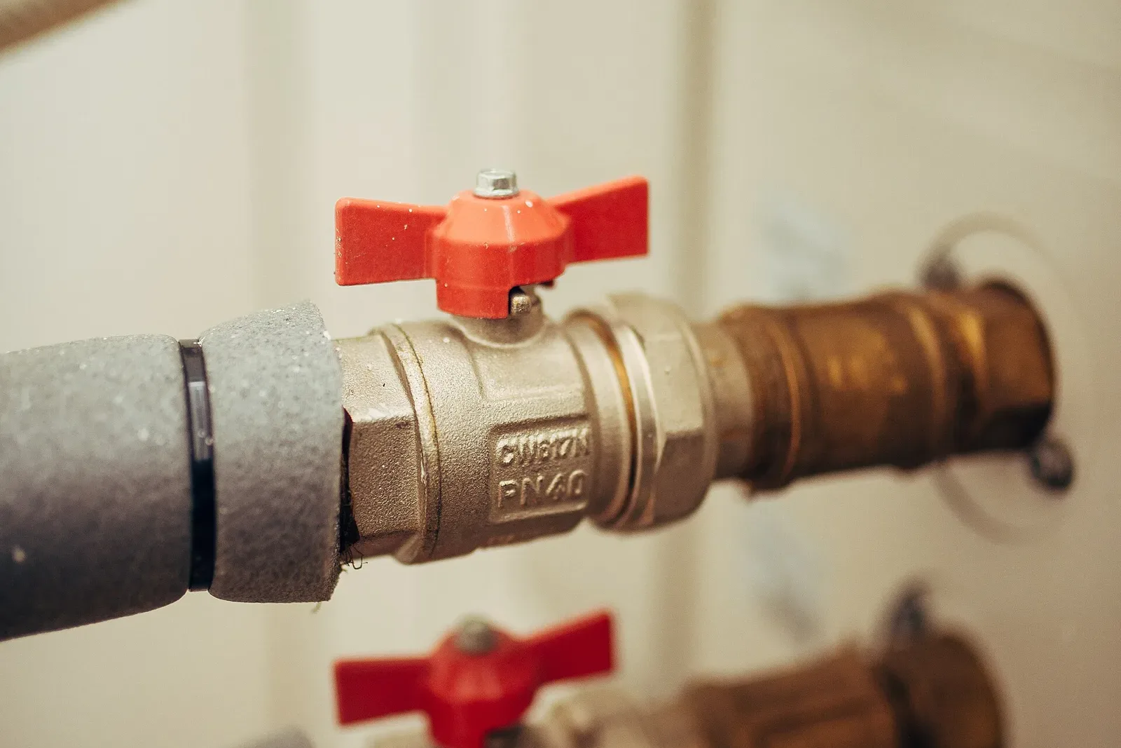 Plumbing pipes and shut-off valves in a building utility room
